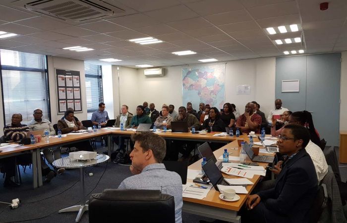 Project team members and stakeholders in large meeting room